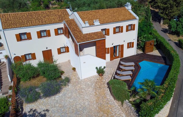 A two-story house with a swimming pool, stone pathway, and surrounding greenery. - Villa San Vito with pool (Sveti Vid - Miholjice)