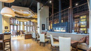 Een modern restaurant met een bar, zitplaatsen en een open haard.