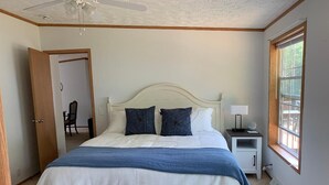 Ein Schlafzimmer mit einem Bett, einem Nachttisch und einem Fenster.