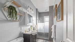 Un baño moderno con inodoro, lavabo y ducha.