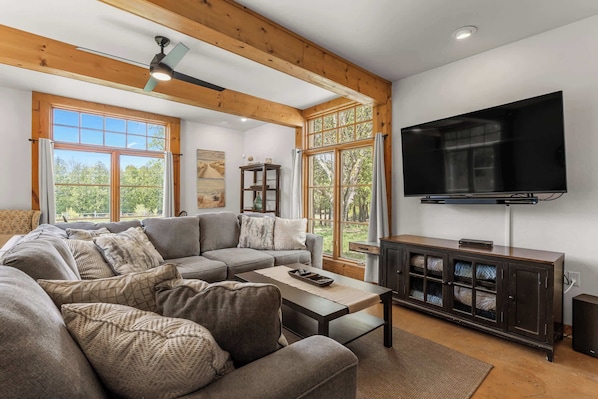 A living room with a sectional sofa, a coffee table, a TV, and a cabinet.