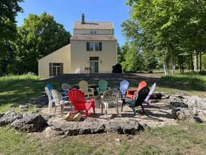 A house with a front porch, outdoor seating, and a natural setting. - Private Home in Sister Bay-Door County, 5 BR (Sister Bay)