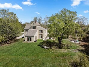 A two-story house with a sloped roof, a front porch, and a well-maintained lawn. - Private Home in Sister Bay-Door County, 5 BR (Sister Bay)