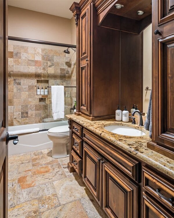 A bathroom with a bathtub, toilet, vanity with a sink, and a shower area. - Pet Friendly, Extravagant North Scottsdale Estate - Theater, Bball & more! (Cave Creek)