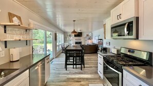 Una cocina moderna con una isla central, electrodomésticos de acero inoxidable y vistas al exterior.