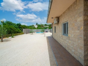 Ein Gebäude aus Stein mit Pool und einem umzäunten Garten.