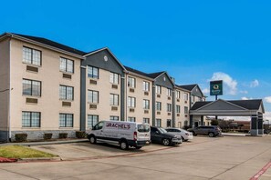 Un hôtel doté d’un parking, d’un fourgon portant l’inscription « RACHEL’S » et d’une enseigne indiquant « Qualité ».