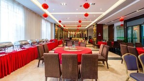 A spacious banquet hall with round tables, red tablecloths, and red lanterns hanging from the ceiling. - Uchoice Hotel (Ganzhou)