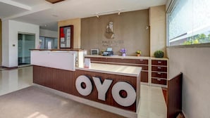 Una recepción con el nombre "Emerald Towers Apartment" y el logotipo "OYO".