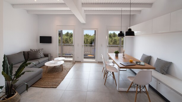 A modern living room with a sofa, coffee table, and dining area. - High-end Luxury Apartment & Convenient Location (Tsoukalades)