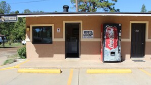 Un motel avec un distributeur automatique de Coca-Cola, une enseigne indiquant « Laverie pour les clients du motel » et une autre indiquant « Sens unique ».