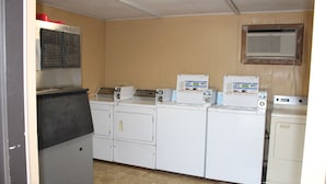 Une buanderie équipée d’un lave-linge, d’un sèche-linge et de plusieurs sèche-linge superposés.