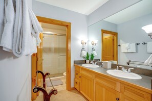 A modern bathroom with two sinks, a large mirror, and wooden cabinetry. - Ski-In/Out Condo w/ Hot Tub Access in Keystone! (Keystone)