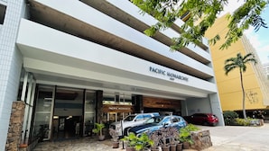 A building with the sign 'PACIFIC MONARCH' and a stone-paved entrance.