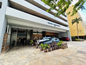 A building with a sign reading 'PACIFIC MONARCH' and a stone-paved entrance. - "STEPS AWAY FROM THE WAIKIKI BEACH STUDIO WITH OCEAN VIEW" (Honolulu)