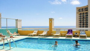 A rooftop pool with lounge chairs and a view of the ocean. - "STEPS AWAY FROM THE WAIKIKI BEACH STUDIO WITH OCEAN VIEW" (Honolulu)
