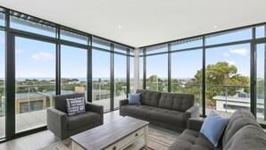 Un ampio balcone con ampie finestre che offre vista sulla città e sul verde.