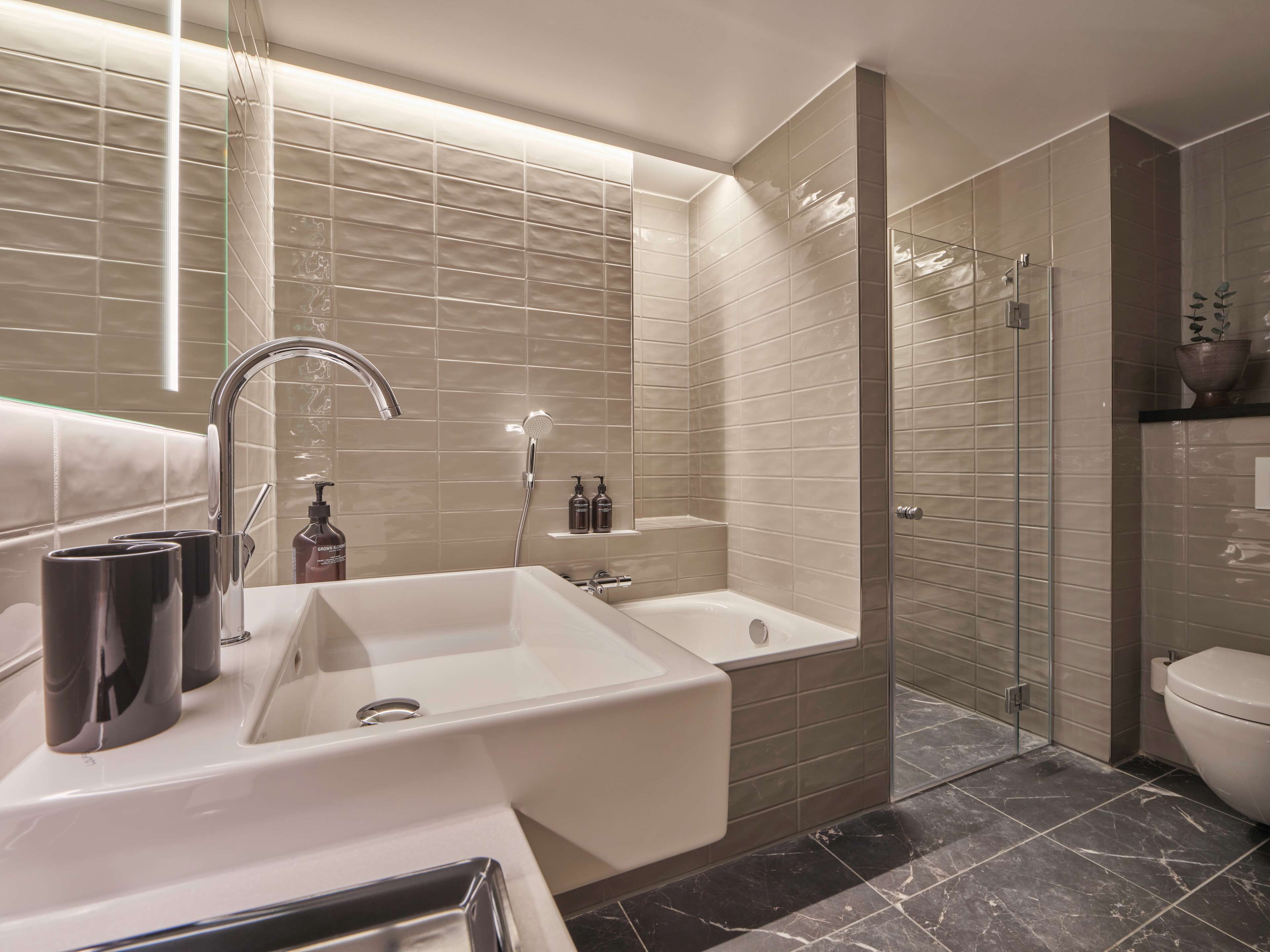 Ein modernes Badezimmer mit einem großen Waschbecken, einer Badewanne und einer begehbaren Dusche.
