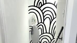 A staircase with a patterned carpet and a wall with a black and white abstract design.