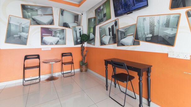 A hotel room with multiple mirrors, a television, a small table, and two chairs. - OYO 90296 Red Orange Hotel Port Klang (Pelabuhan Klang)