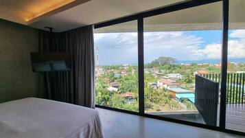 Un dormitorio con un ventanal que ofrece vistas a una zona residencial.
