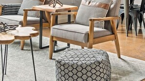 Una sala de estar moderna con un ventanal grande, un comedor con mesa y sillas, y una pared decorada con fotografías enmarcadas.