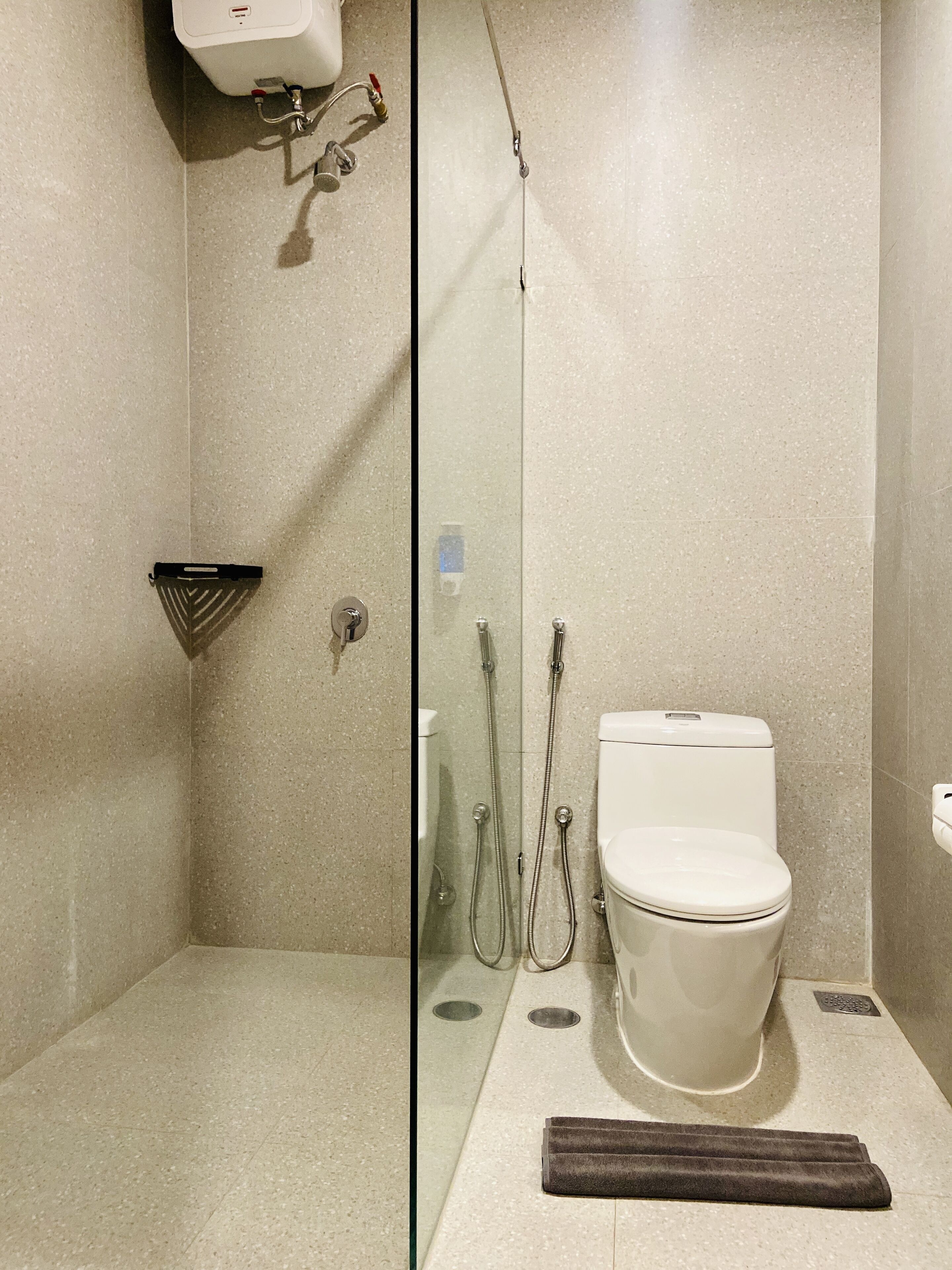 Un bagno moderno con cabina doccia in vetro, un water e un lavandino.