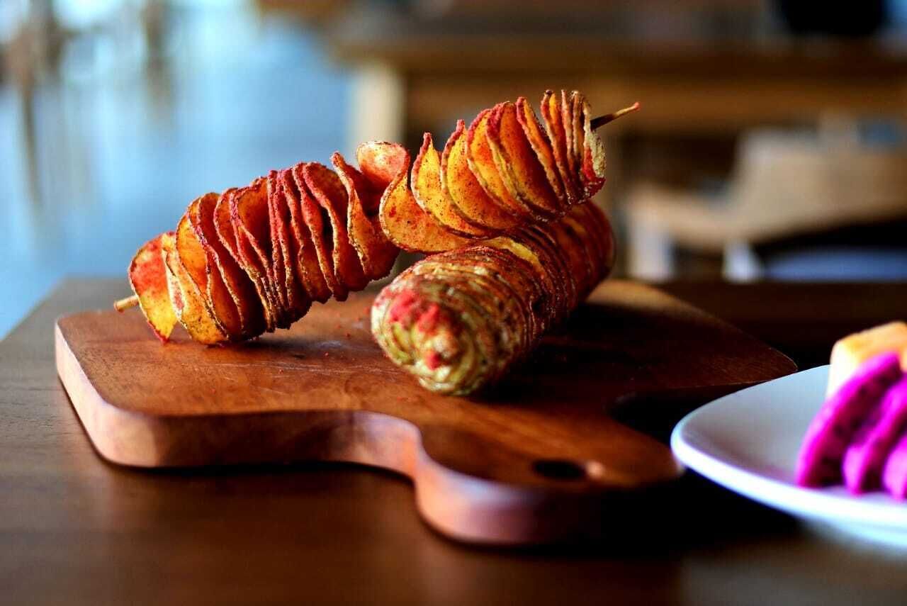 A wooden cutting board with a spiral-shaped food item on it.