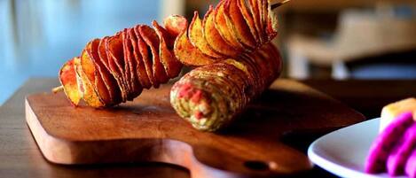 A wooden cutting board with a spiral-shaped food item on it.