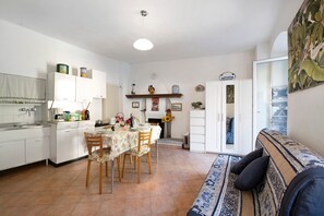 A compact living space with a kitchenette, dining area, and a sofa.