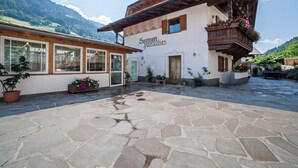 Un bâtiment traditionnel doté d’une cour en pierre, de balcons en bois et d’une enseigne indiquant « Sonnen Paradies ».