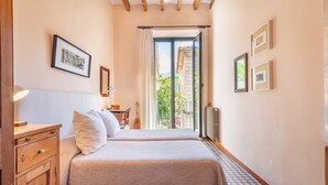 A bedroom with a bed, a wooden nightstand, a desk, and a chair. - Spacious townhouse in the heart of Sóller. (Soller)