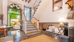 A staircase with patterned steps, a white chair with 'BOCK 3 NORTH' text, a lamp, and a radiator. - Spacious townhouse in the heart of Sóller. (Soller)