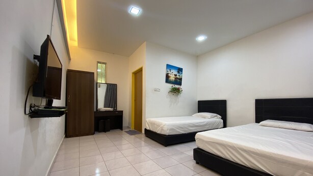 A modern hotel room with two beds, a flat-screen TV mounted on the wall, a small desk, and a door leading to another room. - Hotel O Taman Kota Homestay (Keningau)
