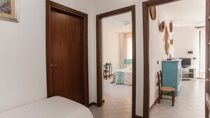 Habitación de hotel con cama, escritorio, silla y televisor.