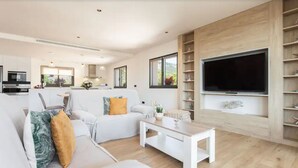 Un salon moderne avec un canapé, une table basse et un téléviseur.