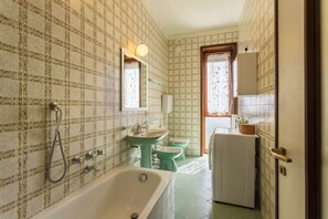 Ein Badezimmer mit Badewanne, Waschbecken, Toilette und Spiegel.