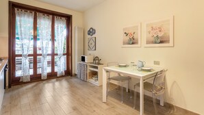 A dining area with a table, chairs, a microwave, and a kettle. - Beautiful two-bedroom energy efficient apartment with large equipped terrace (Brunate)