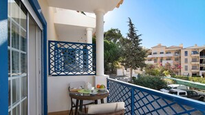 Ein Balkon mit Tisch, Stühlen und einem blauen Geländer.