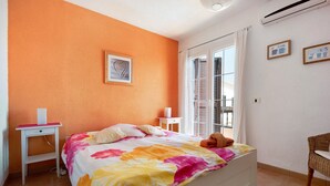 A bedroom with a bed, a nightstand, a chair, and a window with blinds. - Holiday Home Casa Sarita with Shared Pool & Wi-Fi (Arona)
