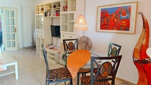 A dining area with a table, chairs, and a television. - Holiday Home Casa Sarita with Shared Pool & Wi-Fi (Arona)