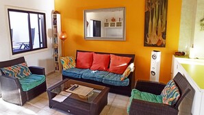 A living room with a sofa, two armchairs, a coffee table, a bookshelf, a mirror, and a painting on the wall. - Casa Dos Ángeles with Mountain Views, Pool, Air Conditioning, Wi-Fi, Garden & Terrace (Arona)