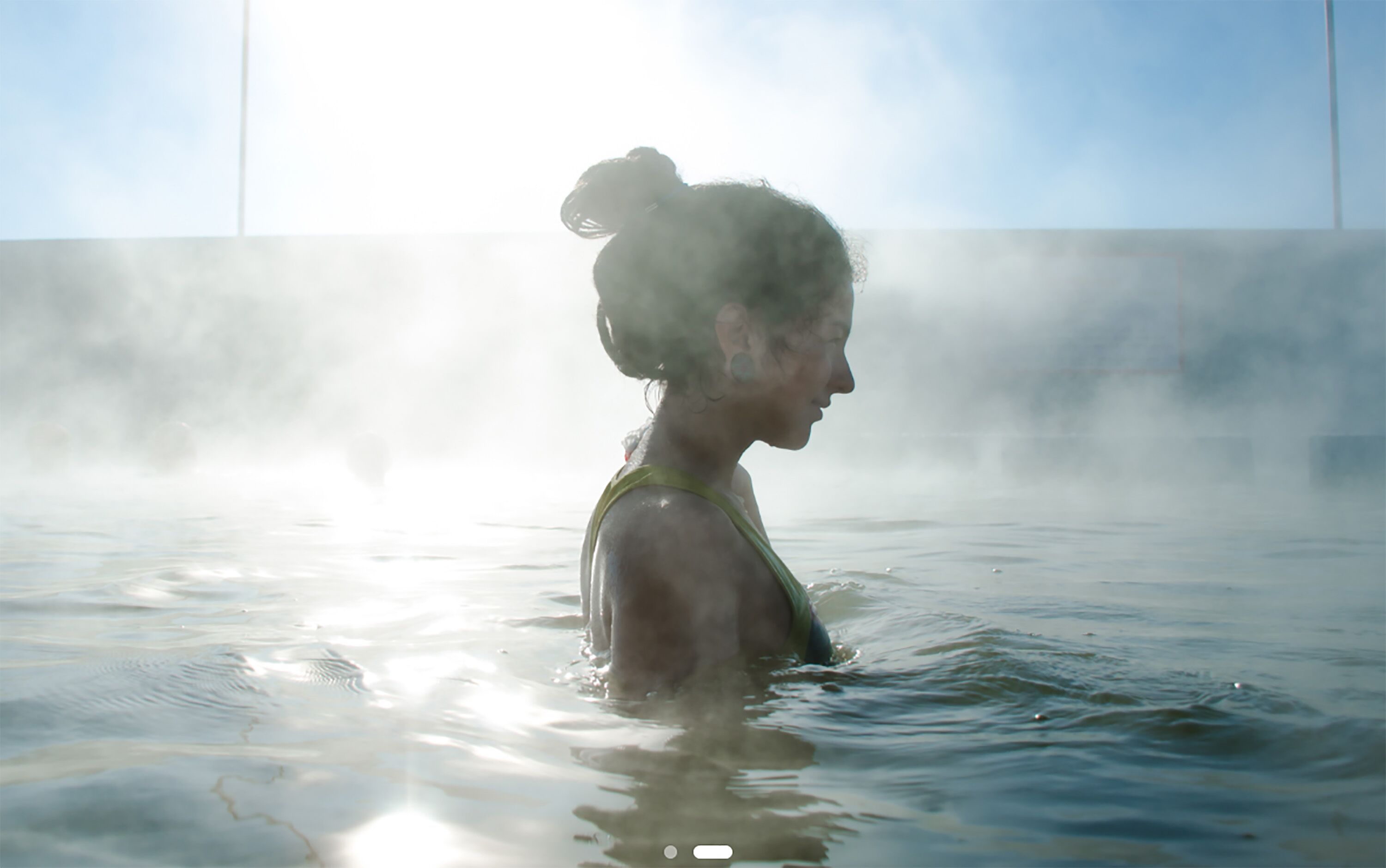 A person in a steam bath with a clear view of the steam and water.