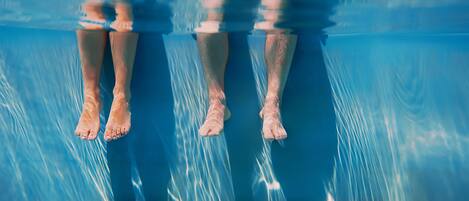 A view of a swimming pool with clear water and visible underwater reflections.