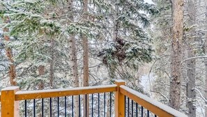 A snowy forest scene with a wooden railing. - Timbernest Condo - 2 BDR Walk to Downtown & Lift! (Breckenridge)