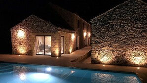 A stone building with a pool in front.