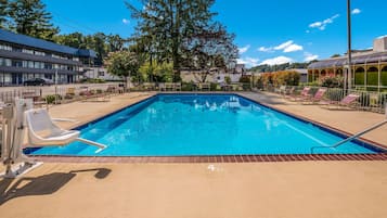 A rectangular swimming pool with a clear blue water surface, surrounded by a brick deck.