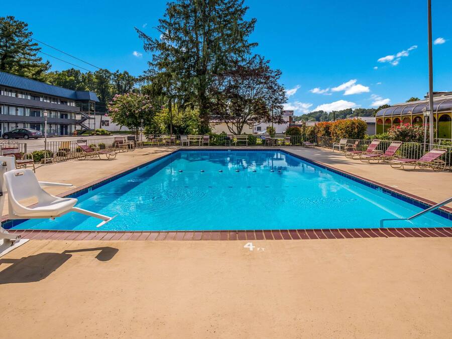 A rectangular swimming pool with a clear blue water surface, surrounded by a brick deck.