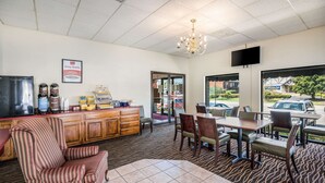 A restaurant with striped chairs, a wooden counter, and a chandelier. - Suburban Studios Middlesboro (Middlesboro)