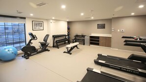 A gym with treadmills, an elliptical, dumbbells, a bench, and a large exercise ball. - MainStay Suites Oak Brook Terrace-Chicago (Villa Park)